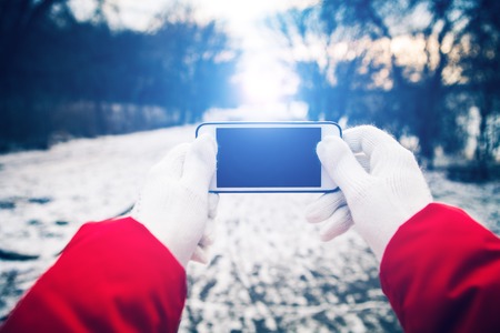 a girl gets on the hip a mobile telephone on a background a winter streetの写真素材