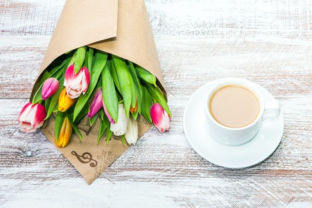tulips and coffees isolated on a wooden tableの写真素材