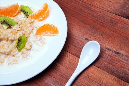 oatmeal in a white dish on a wooden backgroundの写真素材