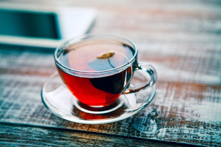 red tea with a tablet on a table in an officeの写真素材