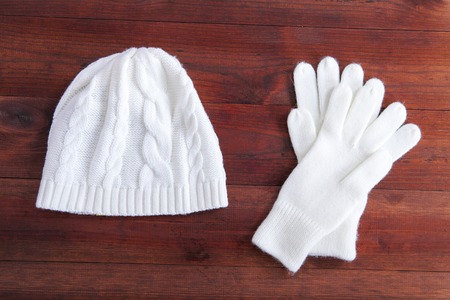 winter gloves and cap on a wooden backgroundの写真素材