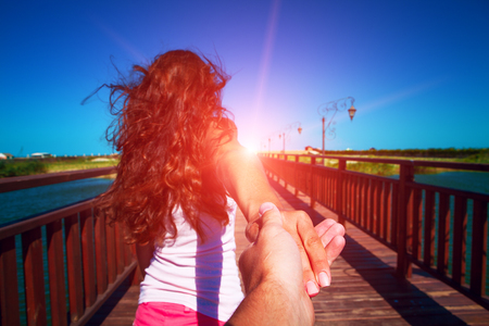 a girl goes on a post holding a fellow on a handの写真素材