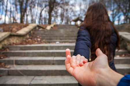 a girl goes on a post holding a fellow on a handの写真素材