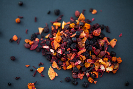 assortment of dry tea in wooden spoon, on black backgroundの写真素材