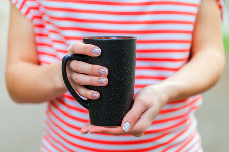 Girl's hands holding a cup of coffeeの写真素材