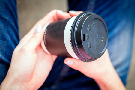 Girl's hands holding a cup of coffeeの写真素材