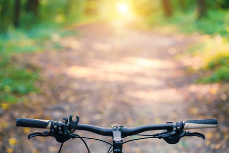 Mountain biking down hill descending fast on bicycle. View from bikers eyes.の写真素材