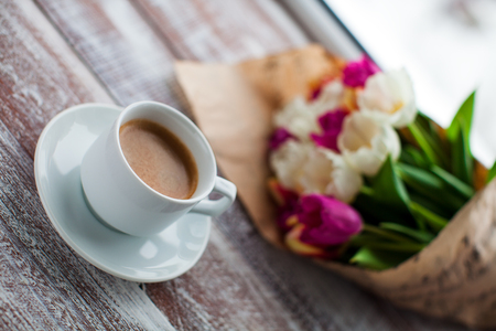 tulips and coffees isolated on a wooden tableの写真素材