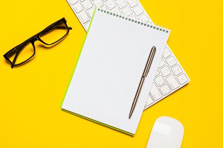 Top view of business working place with cup of coffee, Empty workspace on yellow table background.の写真素材