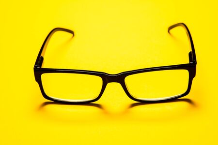 black eye glasses isolated on yellow background