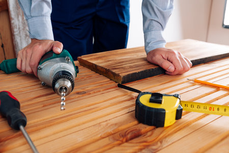 Handyman in blue uniform works with electricity automatic screwdriver. House renovation conception.の写真素材