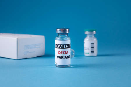 Vaccine bottles covid - 19 delta variant, vials medicine and syringe injection isolated on blue. Coronavirus DELTA 2019-ncov.の写真素材