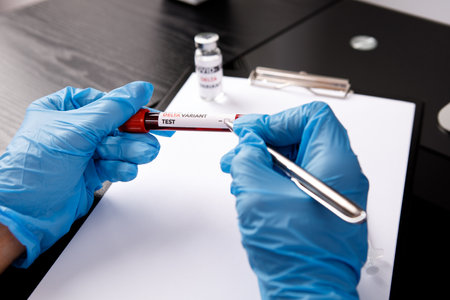 covid 19 delta Variant vaccine and test blood in hand on table background. vaccination against...