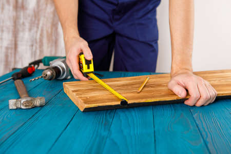 Handyman in blue uniform works with electricity automatic screwdriver. House renovation conception.の写真素材