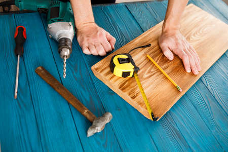 Handyman in blue uniform works with electricity automatic screwdriver. House renovation conception.の写真素材