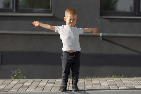 little boy in white t-shirt. space for your logo or design. Mockup for printの写真素材