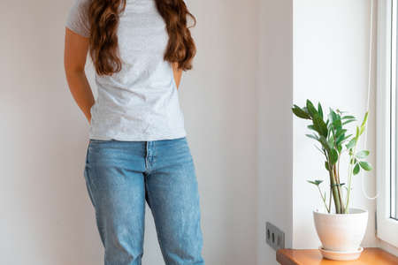 Woman wearing white blank t-shirt with space for your logo, mock up for design indoors.の写真素材