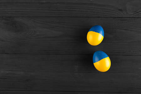 easter egg with the flag of Ukraine on a wooden background. no war in Ukraine