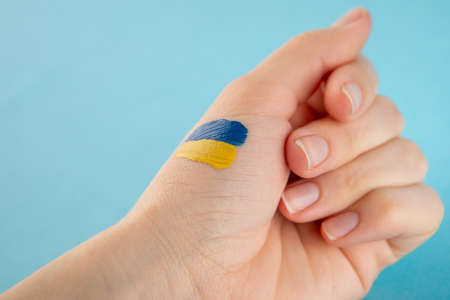 Yellow and blue manicure on the background of the Ukrainian flag.の写真素材