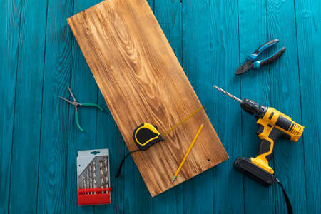Handyman in blue uniform works with electricity automatic screwdriver. House renovation conception.の写真素材