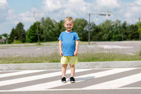a boy in a blue and yellow t-shirt on the background of the street. national flag of ukraine. Mockup for printの写真素材