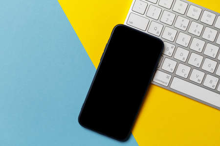 empty screen mobile phone on the background of the flag of ukraine.