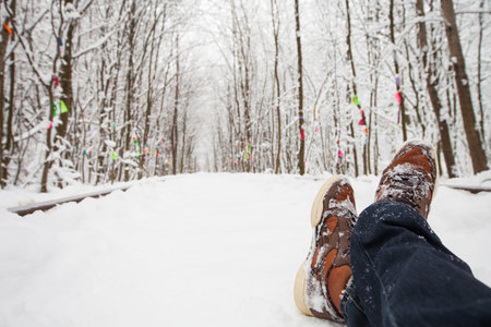 the man lies on snow against the background of the wood.の写真素材