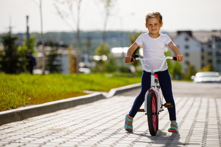 Little girl on a bicycle in summer park. cycling outdoors.の写真素材