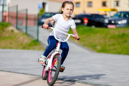 Little girl on a bicycle in summer park. cycling outdoors.の写真素材