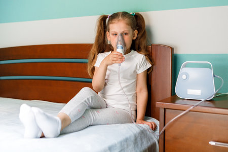 Girl making inhalation with nebulizer at home.の写真素材
