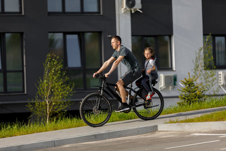 father riding bike with son in bike seat.の写真素材