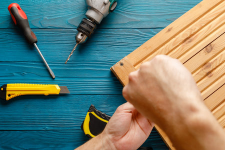 Handyman in blue uniform works with electricity automatic screwdriver. House renovation conception.の写真素材