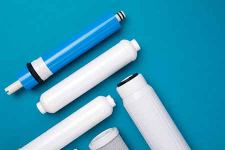 filter cartridges for water on a bright blue background. Installation of reverse osmosis water purification system.の写真素材
