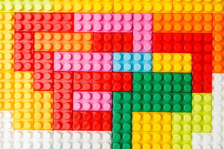 hand stacking up the colorful plastic block. the child is playing with the constructor