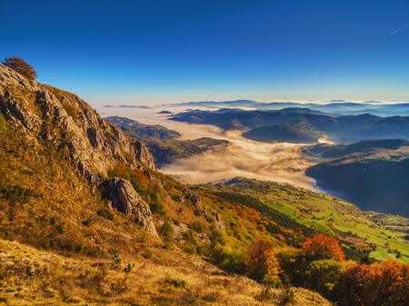 Aerial shot of mountain peaks above clouds in autumn. MuÄanj mountain near Ivanjica in West Serbia.の写真素材