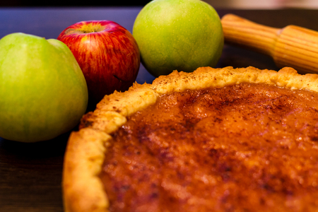 Sweet apple pie on a table with applesの写真素材
