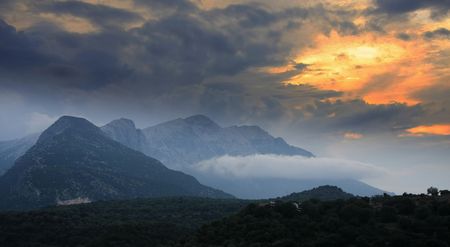 Dramatic cloudy sunset in high mountainの写真素材