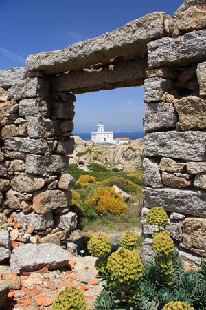 View of white lighthouse through an arch of stoneの写真素材