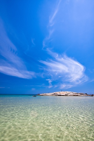 Rock island over emerald water under a blue skyの写真素材