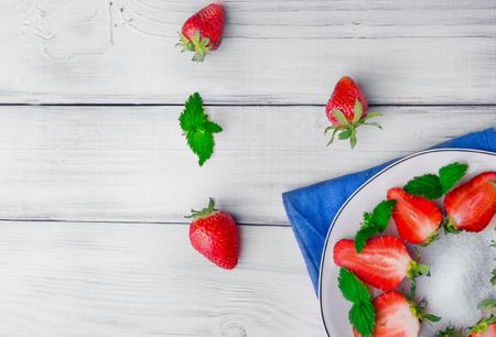 Slice of strawberry with leaf of mint  on white plate and three bery .Free spaceの写真素材