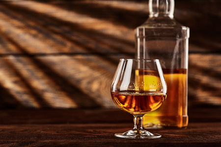 Glass and bottle of Cognac on wodden table.Wooden backgroundの写真素材