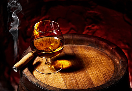 Cognac and Cigar on old oak barrel.Red stone backgroundの写真素材