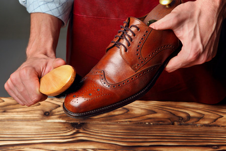 Shoes master (man) polishing leather shoes with brushの写真素材