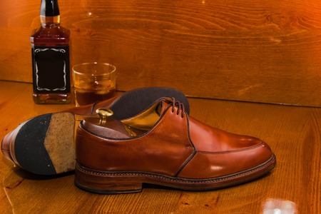 bottle of whiskey luxury shoes polished.warm picture.の写真素材