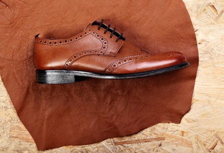 Leather brogues shoes on pieces of leather.O a work table of shoemaker.Copy spaceの写真素材