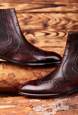 Brown leather chelsea boots polished on pine board. Waxing boots.Copy space.の写真素材