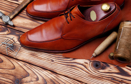 Fashion derby shoes handmade and shoemaker tools awl, nails, skien of thread .Wooden background.copy space.top view.Concept cobblerの写真素材