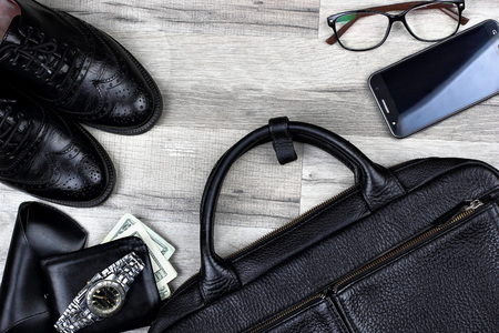 Briefcase, brogues , shoes,wallet with money and watch, cell phone, smarphone.Man accessories in...