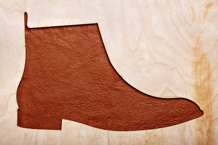 Silhoutte of leather chelsea boots in the center.Top view.Wooden background.Concet shoes shopの写真素材