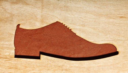 Silhoutte of leather oxfrods shoes in the center.Top view.Wooden background.Concet shoes shopの写真素材